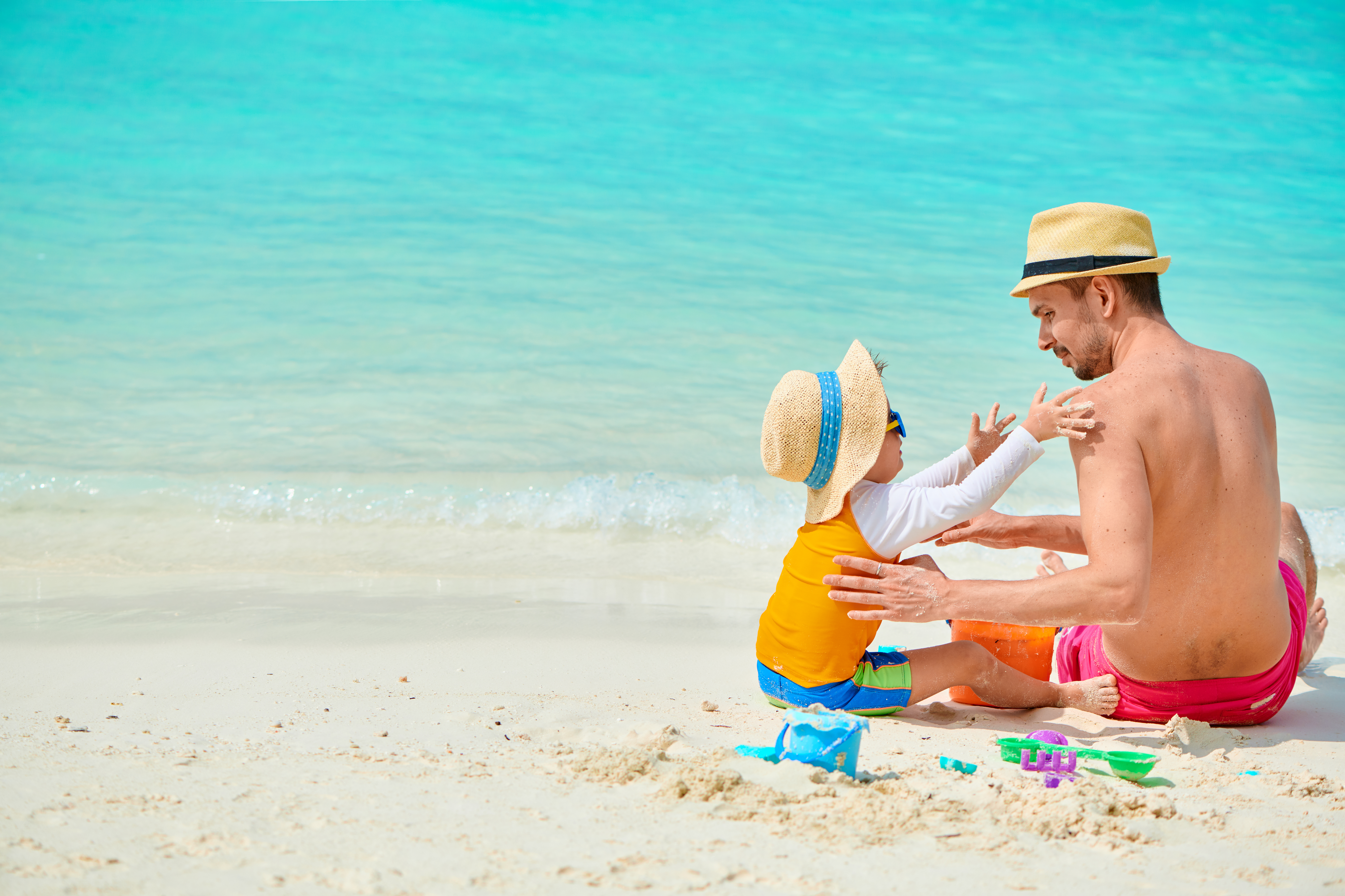 Toddler boy on beach with father
